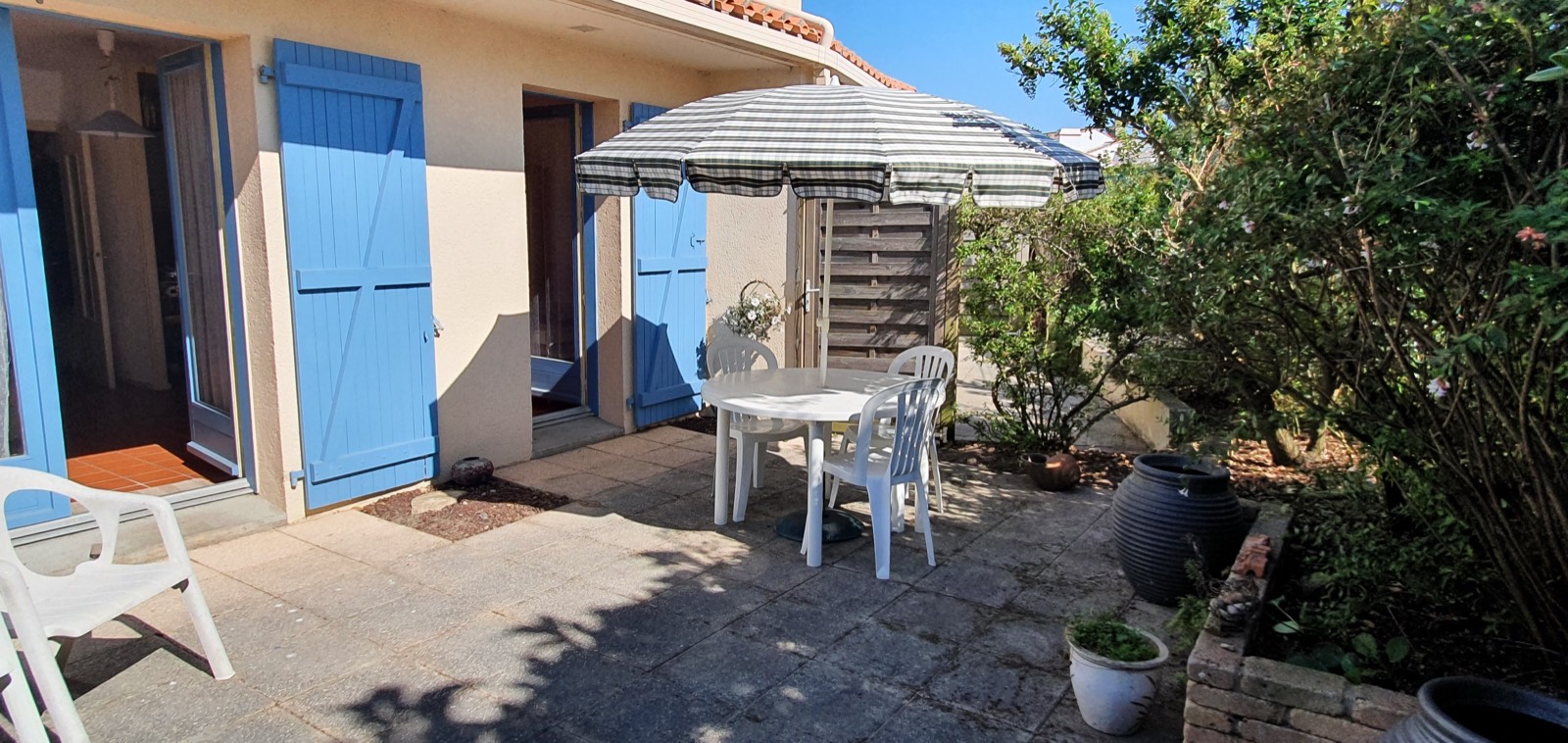 The exterior of B27, with blue shutters and a sunny terrace